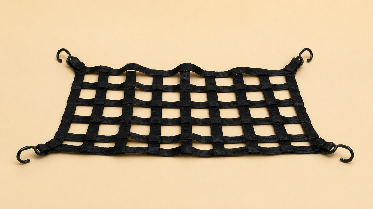 Black woven cargo net with square mesh and steel corner hooks on a beige surface